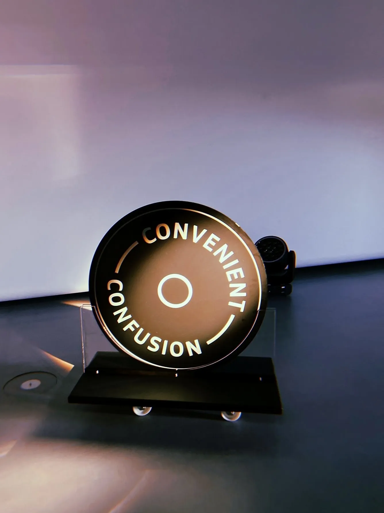Große beleuchtete Münze auf einem Rollbrett, umlaufend beschriftet mit „Convenient Confusion"
