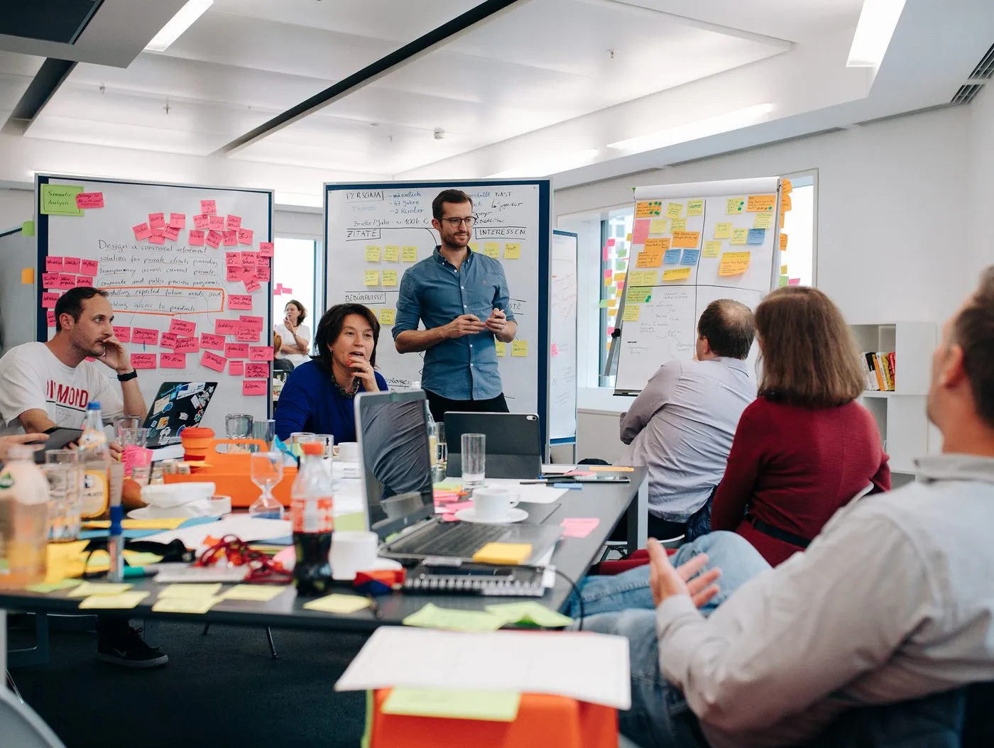Workshop der Deutsche-Bank-Initiative: Ein Team entwickelt vor Whiteboards mit Personas und Geschäftsmodell-Skizzen
