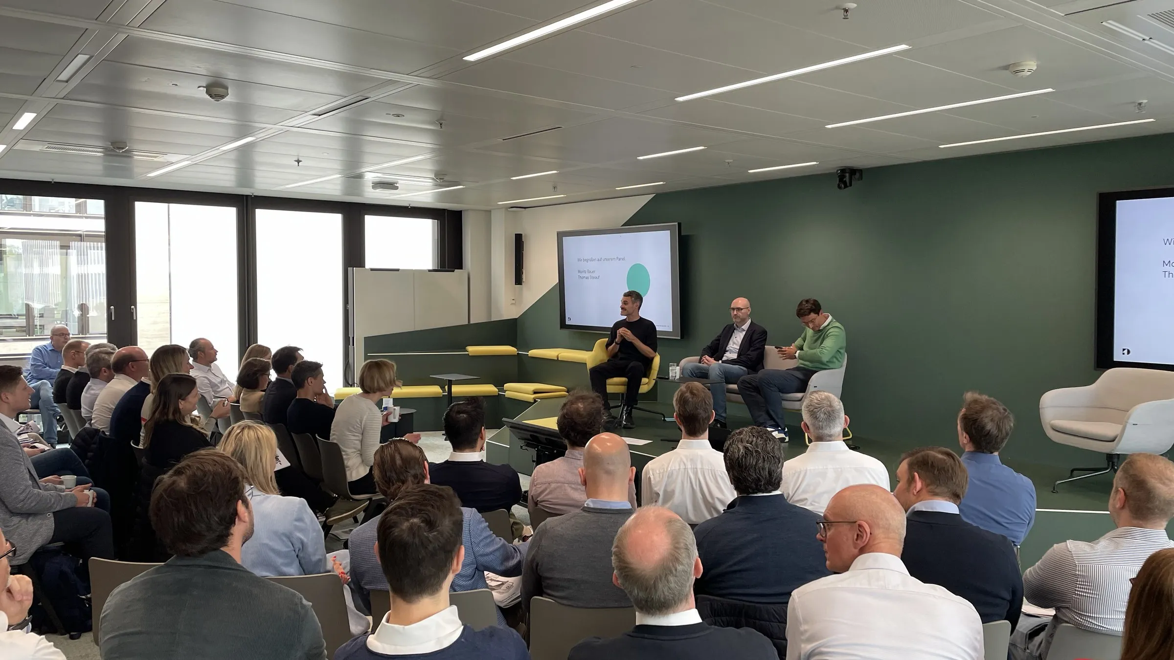 Großes Mitarbeitenden-Event bei Union Investment: Das Publikum verfolgt eine Panel-Diskussion auf der Bühne